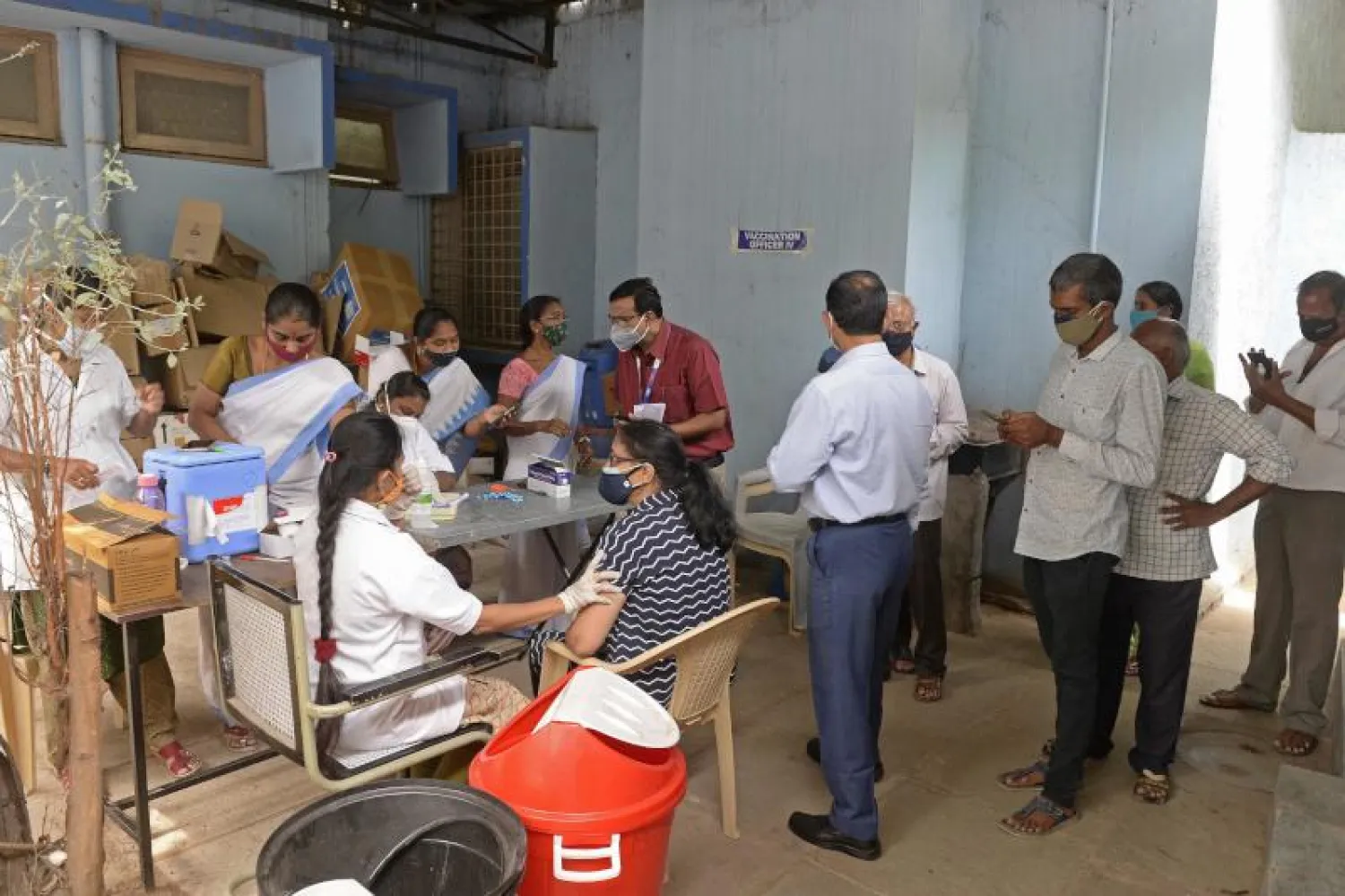 اشخاص يصطفون في طوابير ويسجلون أنفسهم للحصول على لقاح فيروس كورونا  بمركز للرعاية الصحية الأولية بحيدر آباد (ا.ف.ب)