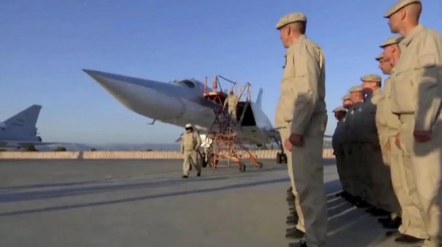 عناصر من الجيش الروسي قرب قاذفة «توبوليف ـــ 22 إم 3» في قاعدة حميميم أمس (رويترز)