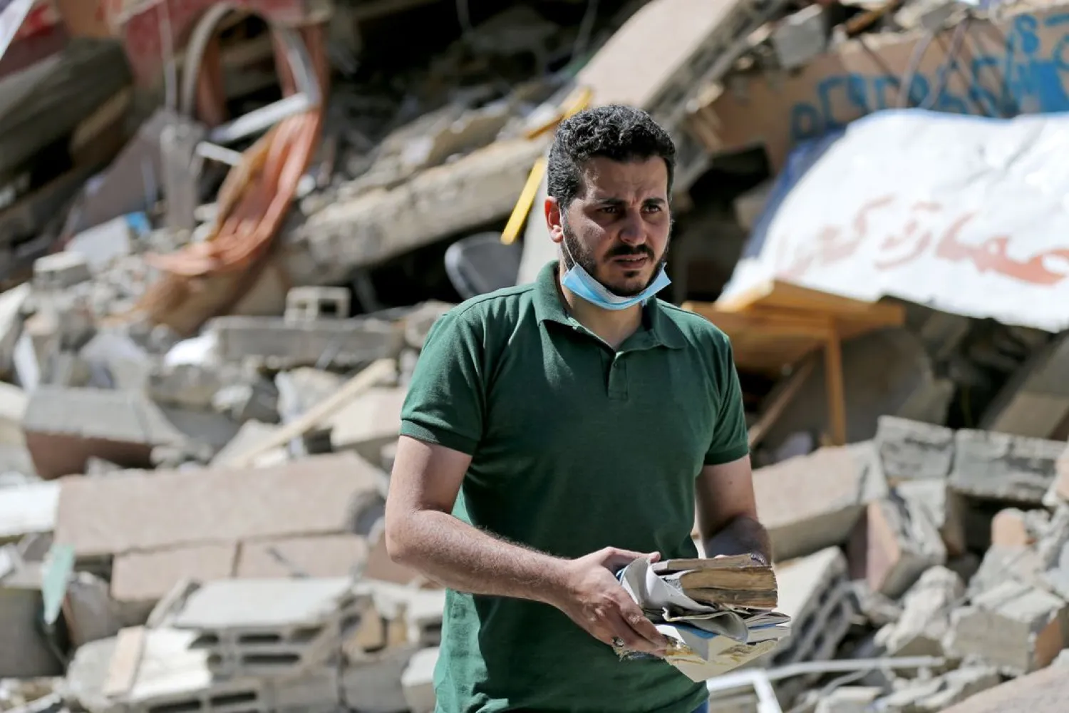 Palestinian Shaban Esleem collects books from his bookstore which was destroyed in Israeli airstrikes during the Israeli-Palestinian fighting, in Gaza City May 24, 2021. (Reuters)