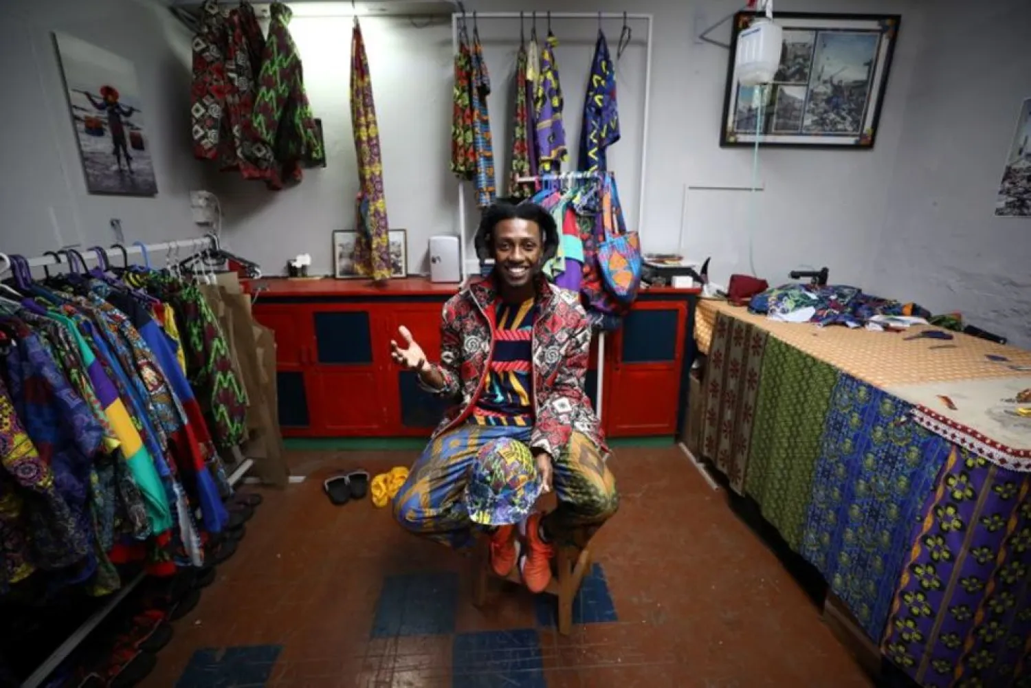 Rwandan-born fashion designer and visual artist Eli Gold sits amongst his designs at his studio in Cape Town, South Africa, May 12 ,2021.Picture taken May 12 ,2021. (Reuters)