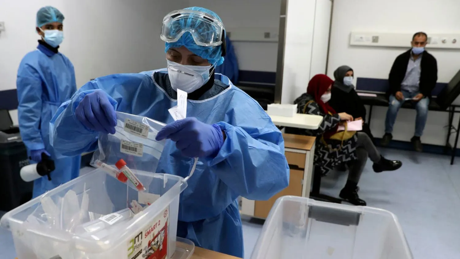 A nurse in protective clothing holds coronavirus testing material, at a center in the Rafik Hariri University Hospital in Beirut. (File photo: AP)

