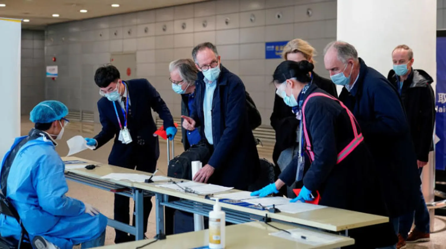 خبراء منظمة الصحة العالمية لدى وصولهم إلى مطار شنغهاي فبراير الماضي (رويترز)