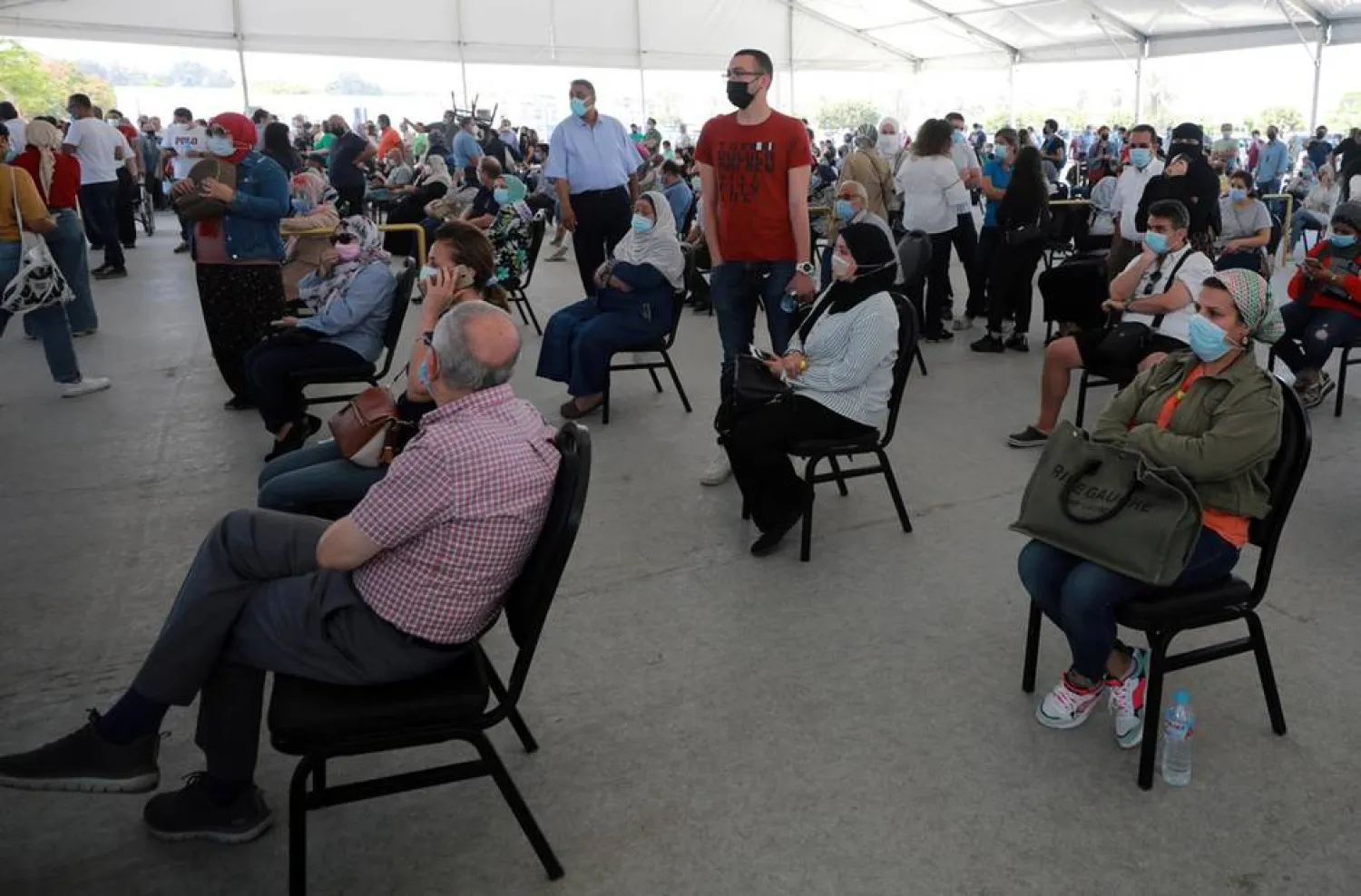 People wait to receive a dose of the COVID-19 vaccine at a mass immunization venue inside Cairo's International Exhibition Centre. EPA