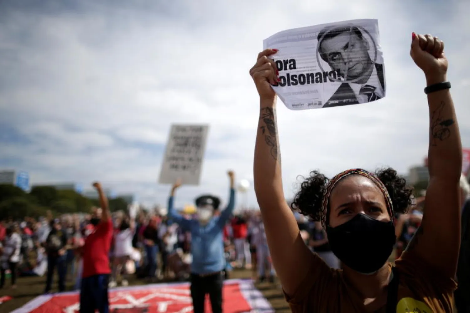 محتجون يرفعون صوراً ولافتات معارضة للرئيس البرازيلي (رويترز)