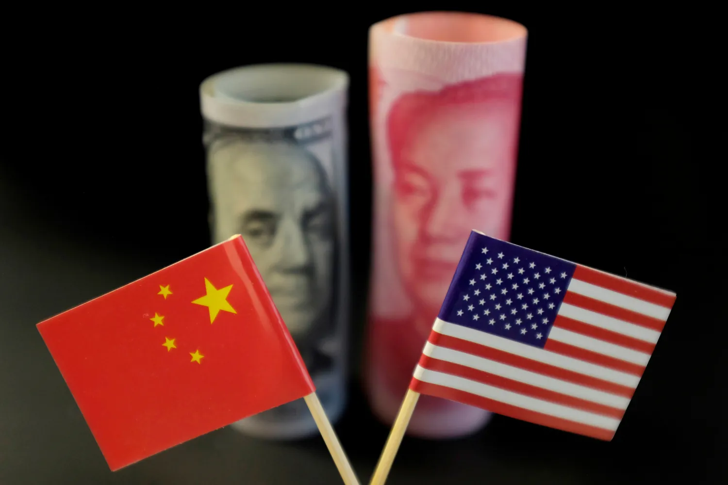 FILE PHOTO: US and Chinese flags are seen in front of a US dollar banknote featuring American founding father Benjamin Franklin and a China's yuan banknote featuring late Chinese chairman Mao Zedong in this illustration picture taken May 20, 2019. REUTERS/Jason Lee/Illustration/File Photo