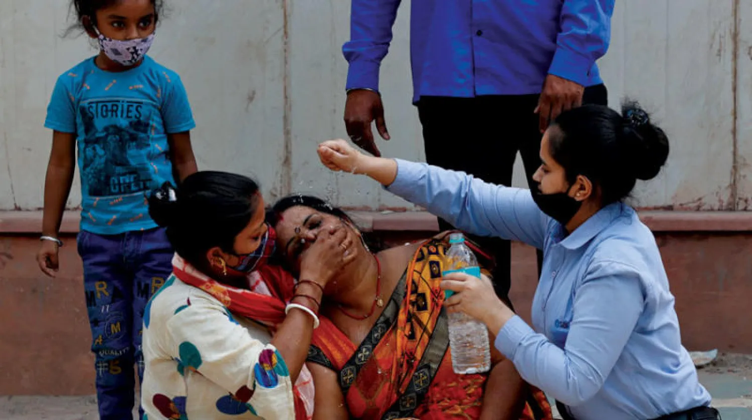 مواساة امرأة بعد وفاة زوجها بسبب فيروس كورونا (COVID-19) خارج مشرحة مستشفى COVID-19 في مومباي بالهند (رويترز)