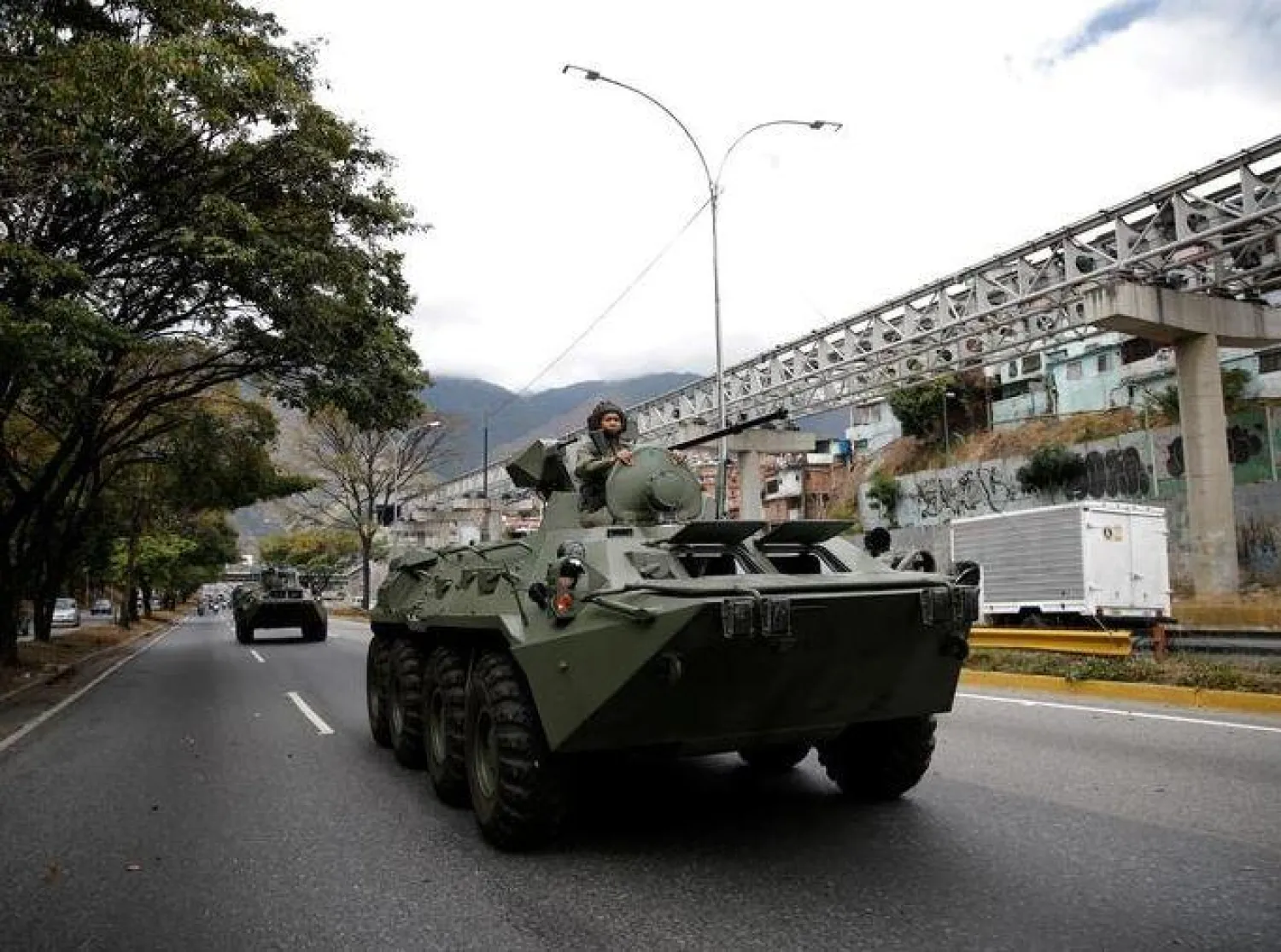 جندي في عربة مدرعة تسير على طريق سريع خلال مناورة عسكرية في كراكاس (ارشيفية-رويترز)