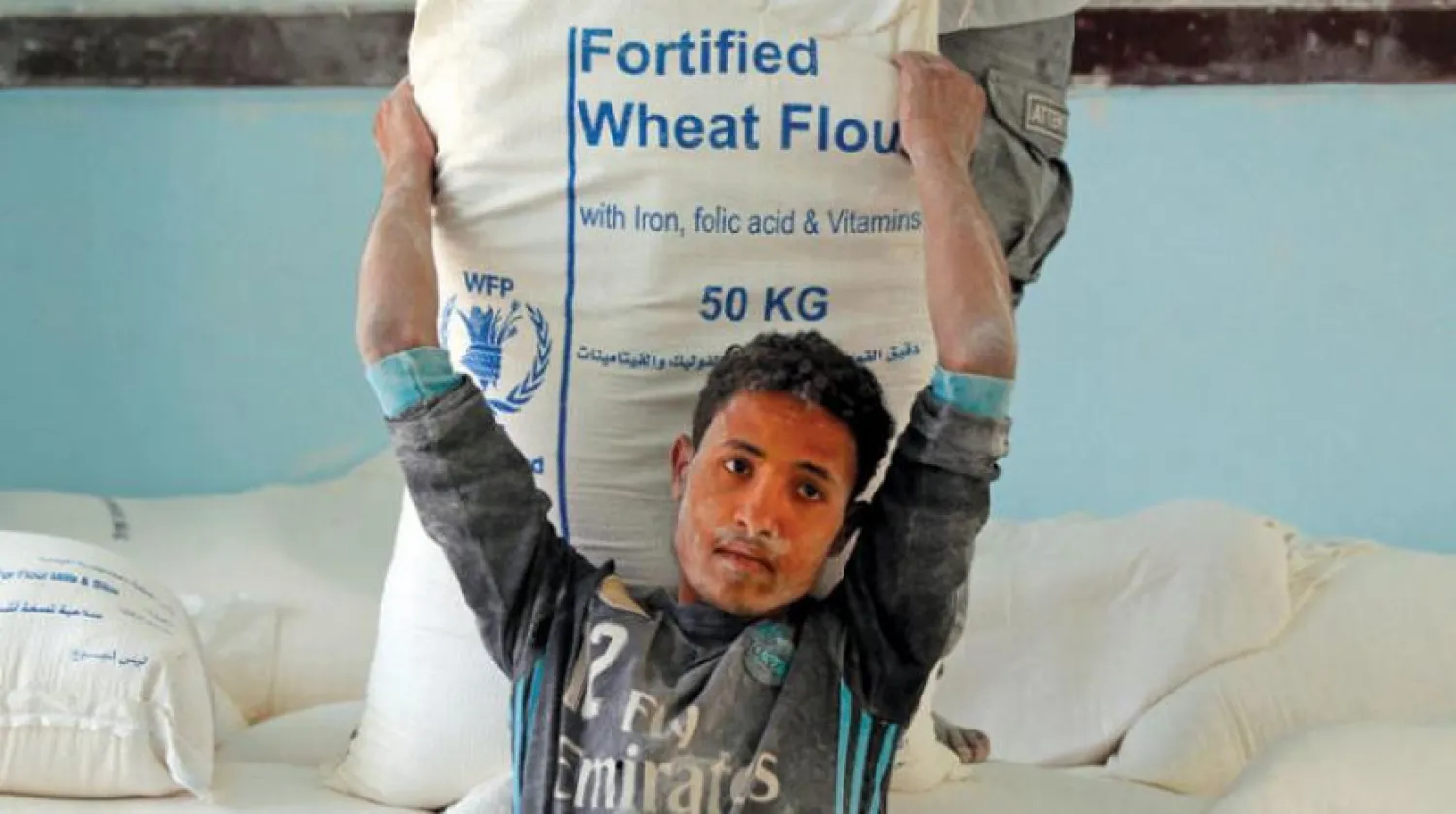 Yemenli bir çocuk Sana’daki Dünya Gıda Programı’ndan (WFP) yardım aldığı sırada. (AFP)