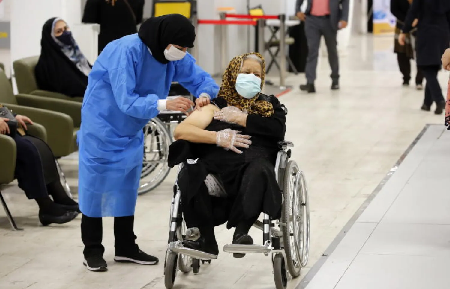 سيدة مسنة تتلقى لقاح «سينوفارم» في طهران (إ.ب.أ)