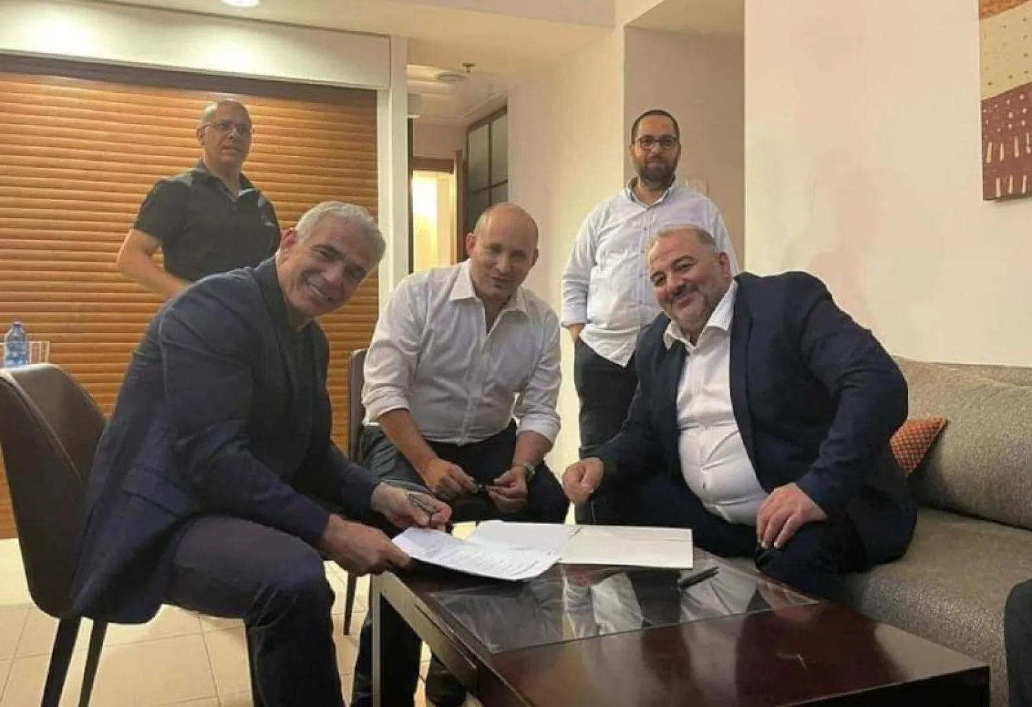 توقيع ثلاثي لحكومة التغيير الإسرائيلية... من اليمين منصور عباس ونفتالي بينيت ويائير لابيد