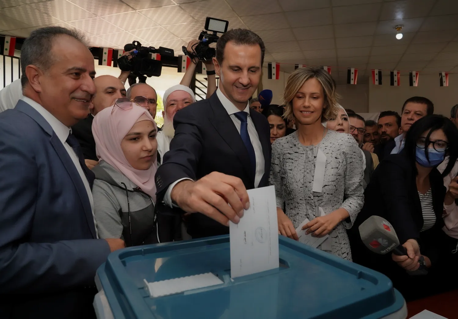 Syria's President Bashar al-Assad, stands next to his wife Asma as he casts his vote, during the country's presidential elections in Douma, Syria, in this handout released by SANA on May 26, 2021. SANA/Handout via REUTERS