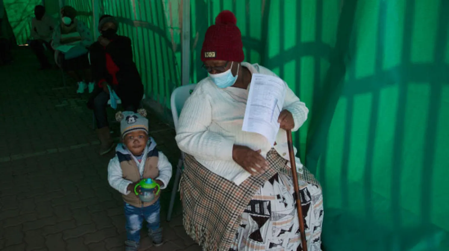 مُسنّ يصطحب طفلاً إلى مركز تلقيح ضد «كورونا» في جنوب أفريقيا (أ.ب)