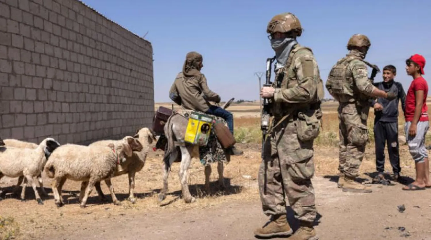 US soldiers talk with Syrian boys in northeastern Syria. AFP file photo
