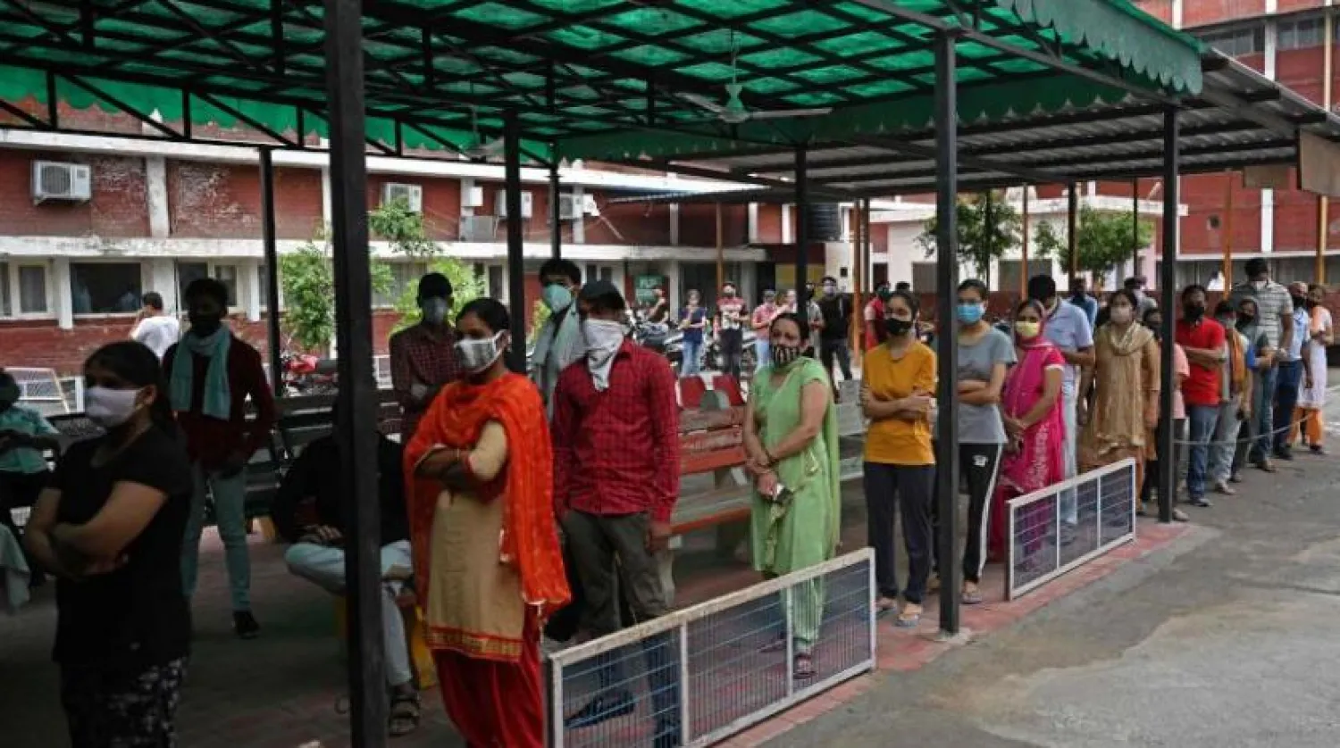 İnsanlar Hindistan'ın Jind kentindeki bir hastane önünde bir doz koronavirüs aşısı olmak için kuyruğa girdi (AFP)