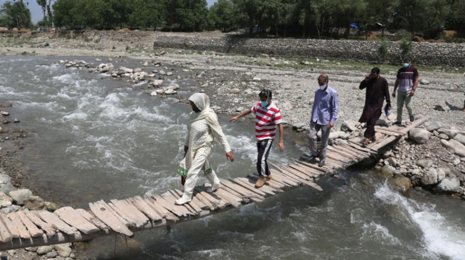 طبيبة وفريقها يتّجهون نحو قرية في كشمير الهندية ضمن حملة تطعيم أمس (إ.ب.أ)