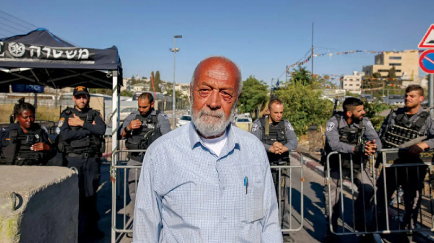 محمد صباغ أحد الذين ينتظرون إخلاء بيوتهم في حي الشيخ جراح يقف أمام الأمن الإسرائيلي (أ.ف.ب)