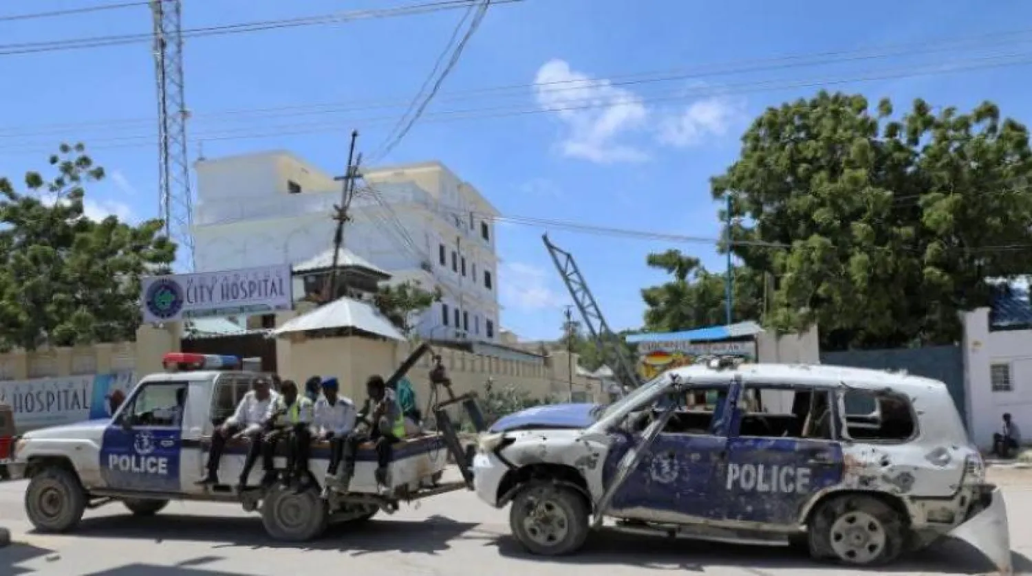 Somali polisi Mogadişu'da önceki intihar saldırısının gerçekleştiği bölgeden zarar gören bir aracı çekiyor. (Reuters)