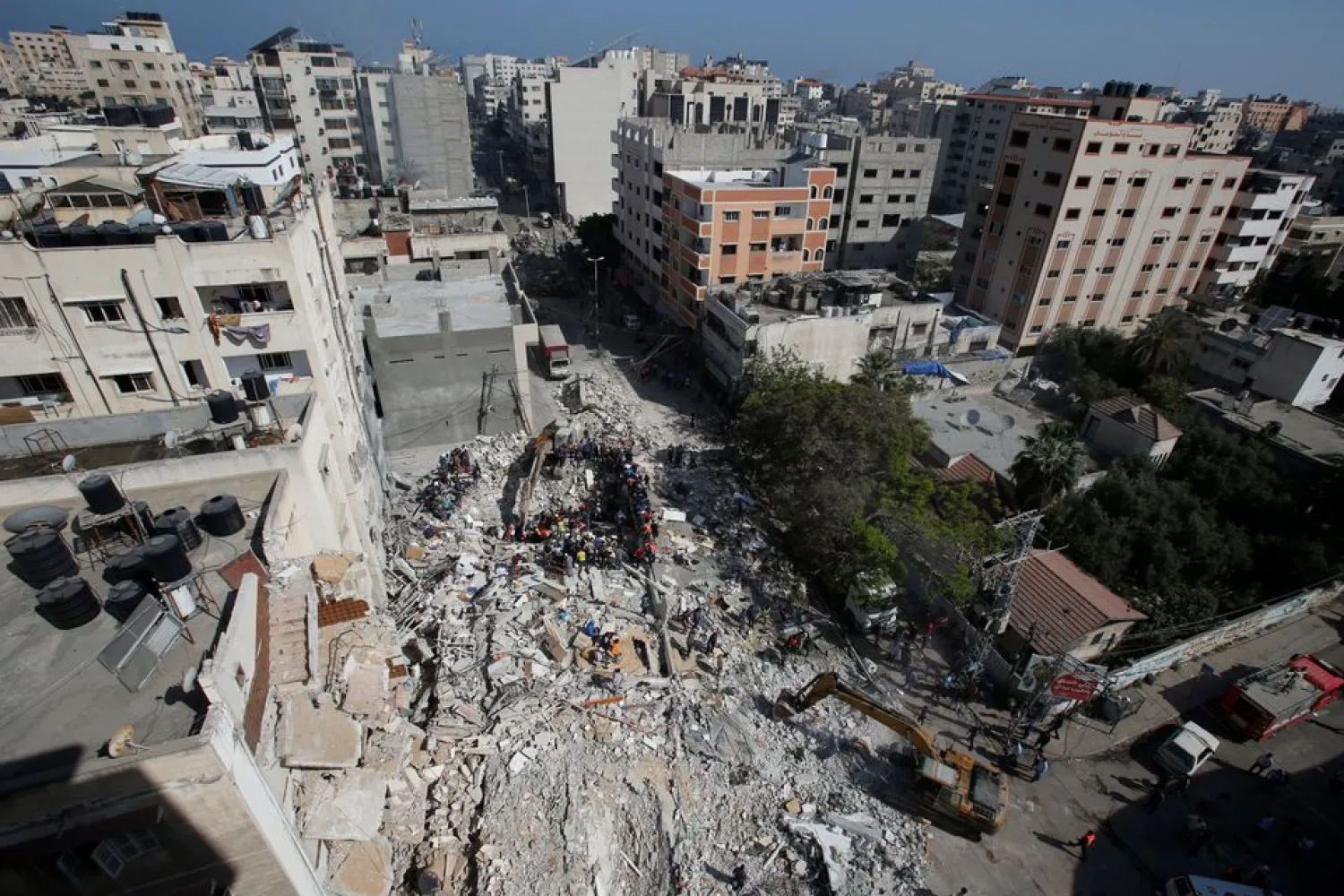 Rescuers search for people in the rubble of a building at the site of Israeli airstrikes, in Gaza City May 16, 2021. REUTERS/Mohammed Salem