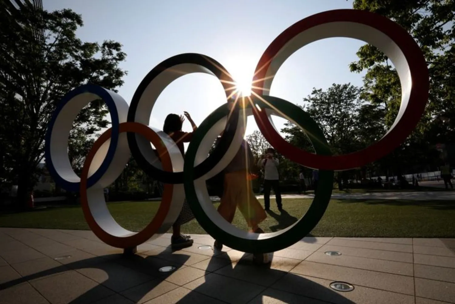 Visitors try to take photos in front of the Olympic Rings monument outside the Japan Olympic Committee headquarters near the National Stadium, May 30, 2021. (Reuters)