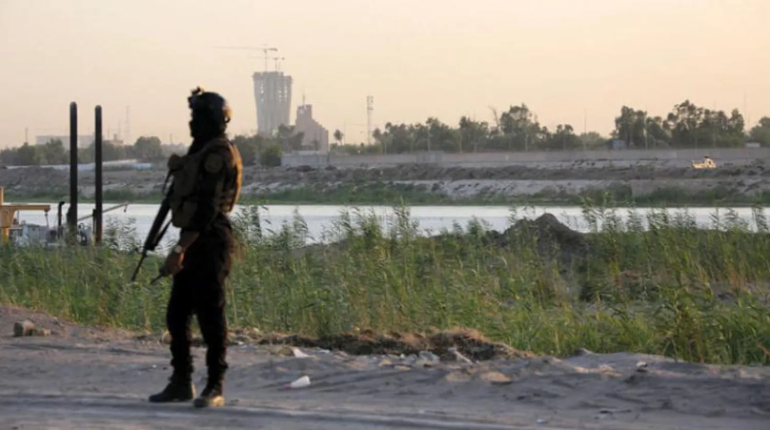 An Iraqi officer during a guard shift with the heavily fortified Green Zone in the background in Baghdad on Sunday. (EPA)