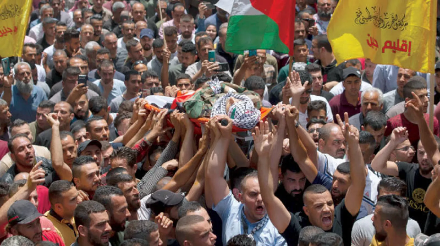 فلسطينيون يشيعون أحد الضابطين في جنين أمس (أ.ب)