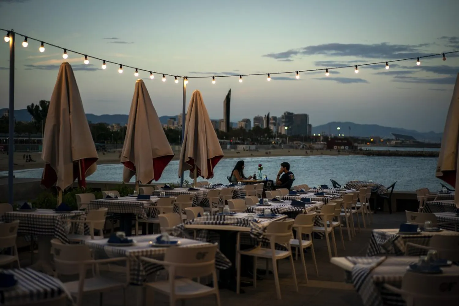 A couple have dinner in an empty restaurant next to the beach in Barcelona, Spain, Wednesday Sept. 23, 2020. (AP)