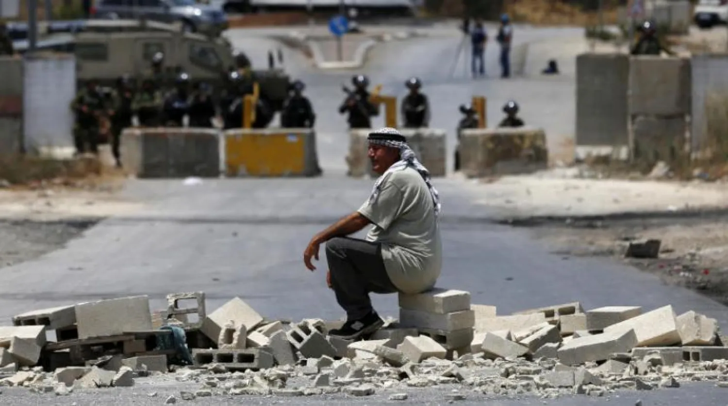 A Palestinian man sits in defiance of Israeli forces during protests against the settlement outposts in Beita village. (dpa)