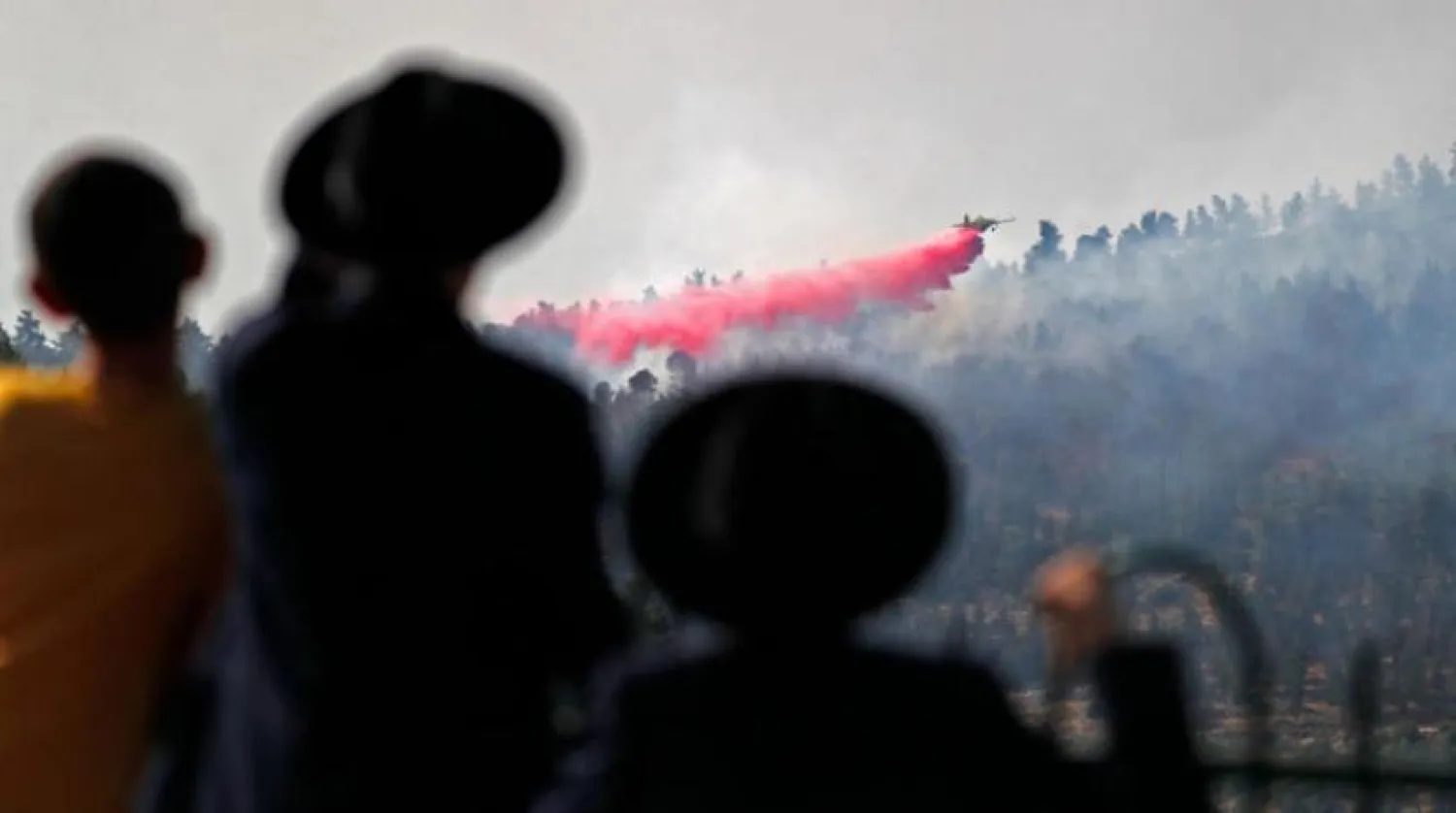Dün Kudüs'ün batısındaki Kibbutz Neve Ilan yakınlarındaki ormanda çıkan yangını söndürme çalışmalarına katılan bir uçak (AFP)