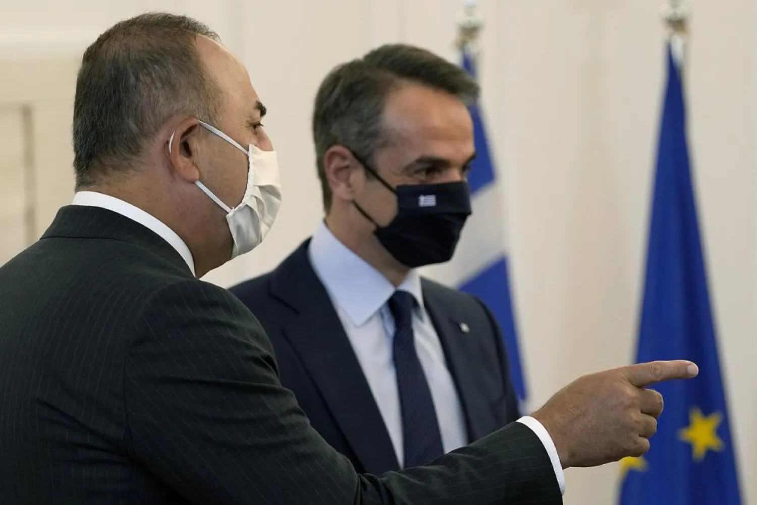 FILE: Greek Prime Minister Kyriakos Mitsotakis, right, speaks with his Turkish counterpart Mevlut Cavusoglu before their meeting at Maximos Mansion in Athens, Monday, May 31, 2021. (AP Photo/Petros Giannakouris)
