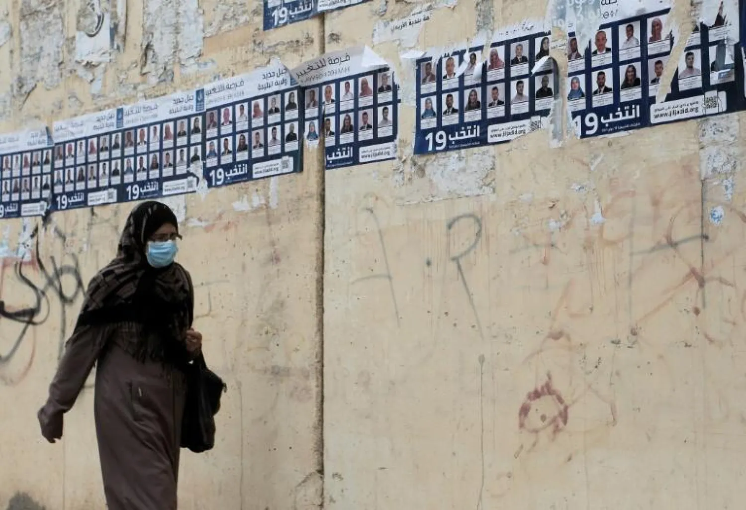 Campaign posters vie for attention on the walls of the capital Algiers ahead of a parliamentary election that few believe will end Algeria's protracted political paralysis - AFP