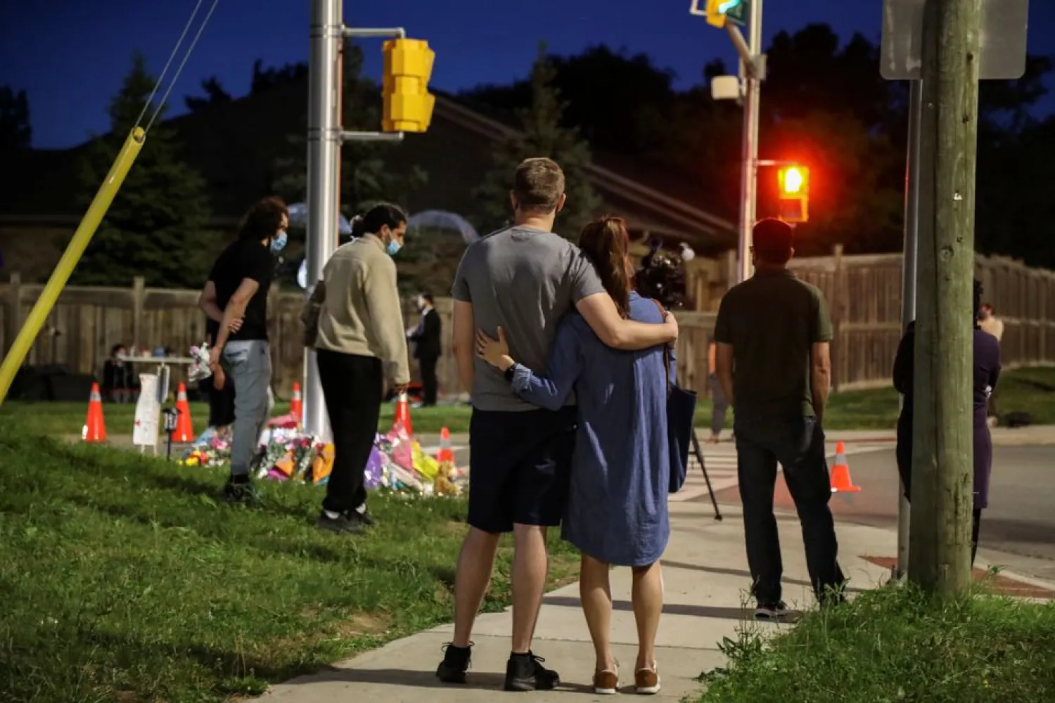 People and members of the media are seen at a makeshift memorial at the fatal crime scene where a man driving a pickup truck jumped the curb and ran over a Muslim family in what police say was a deliberately targeted anti-Islamic hate crime, in London, Ontario, Canada June 7, 2021. REUTERS/Carlos Osorio