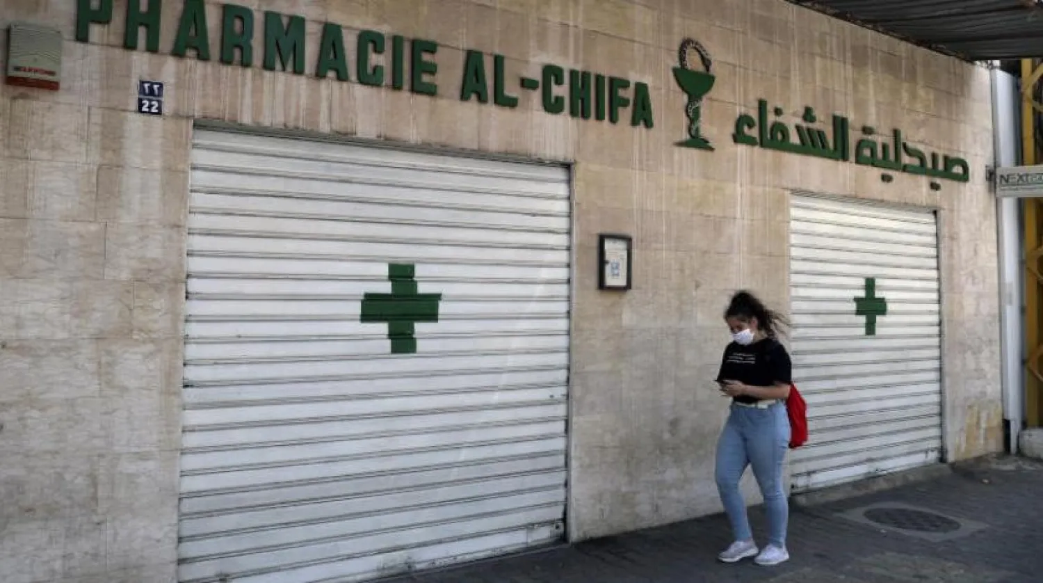 A woman passes by a closed pharmacy in Beirut, Lebanon, Friday, June 11, 2021. (AP Photo/Bilal Hussein)