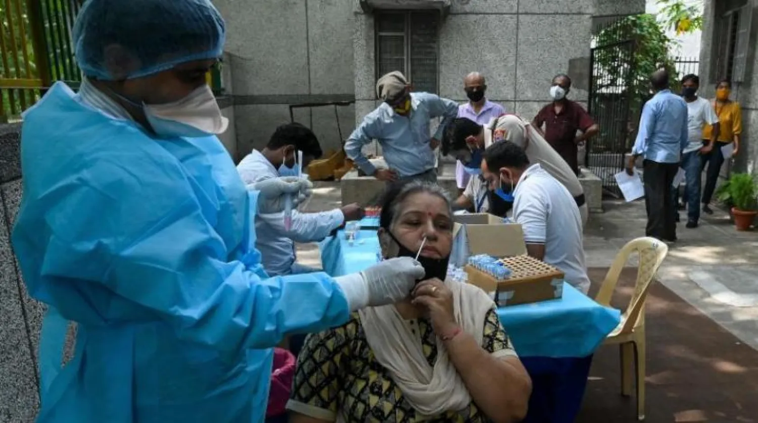 Yeni Delhi'de bir kadın koronavirüs testinden geçiyor (AFP)
