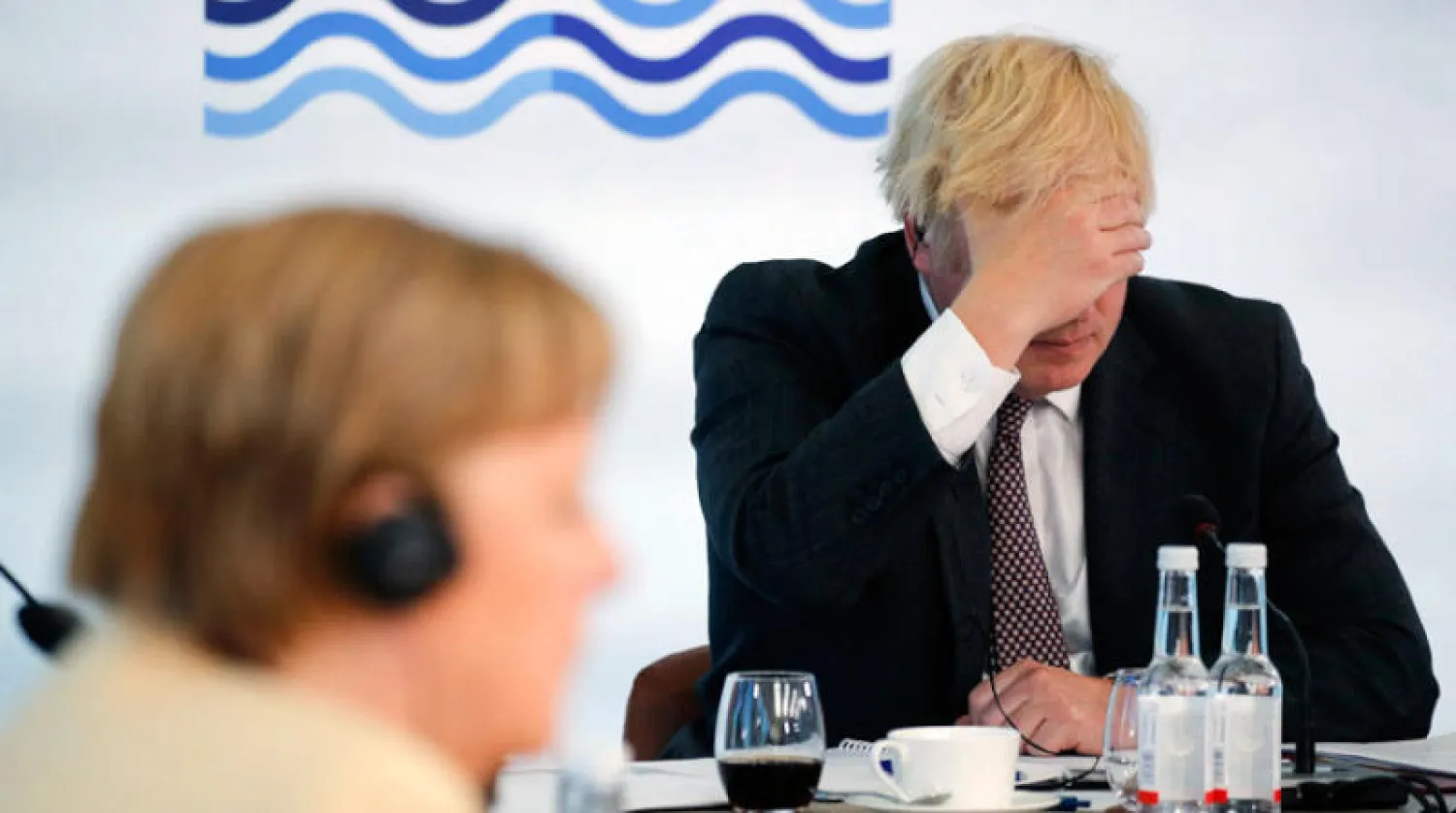 جونسون وميركل خلال محادثات السبع أمس (أ.ب)