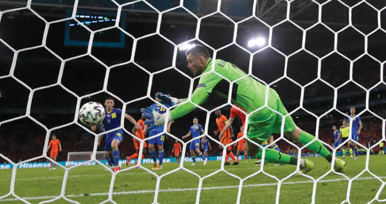 حارس أوكرانيا في محاولة فاشلة للتصدي لرأسية دمفريس التي منحت هولندا الفوز (أ.ب)