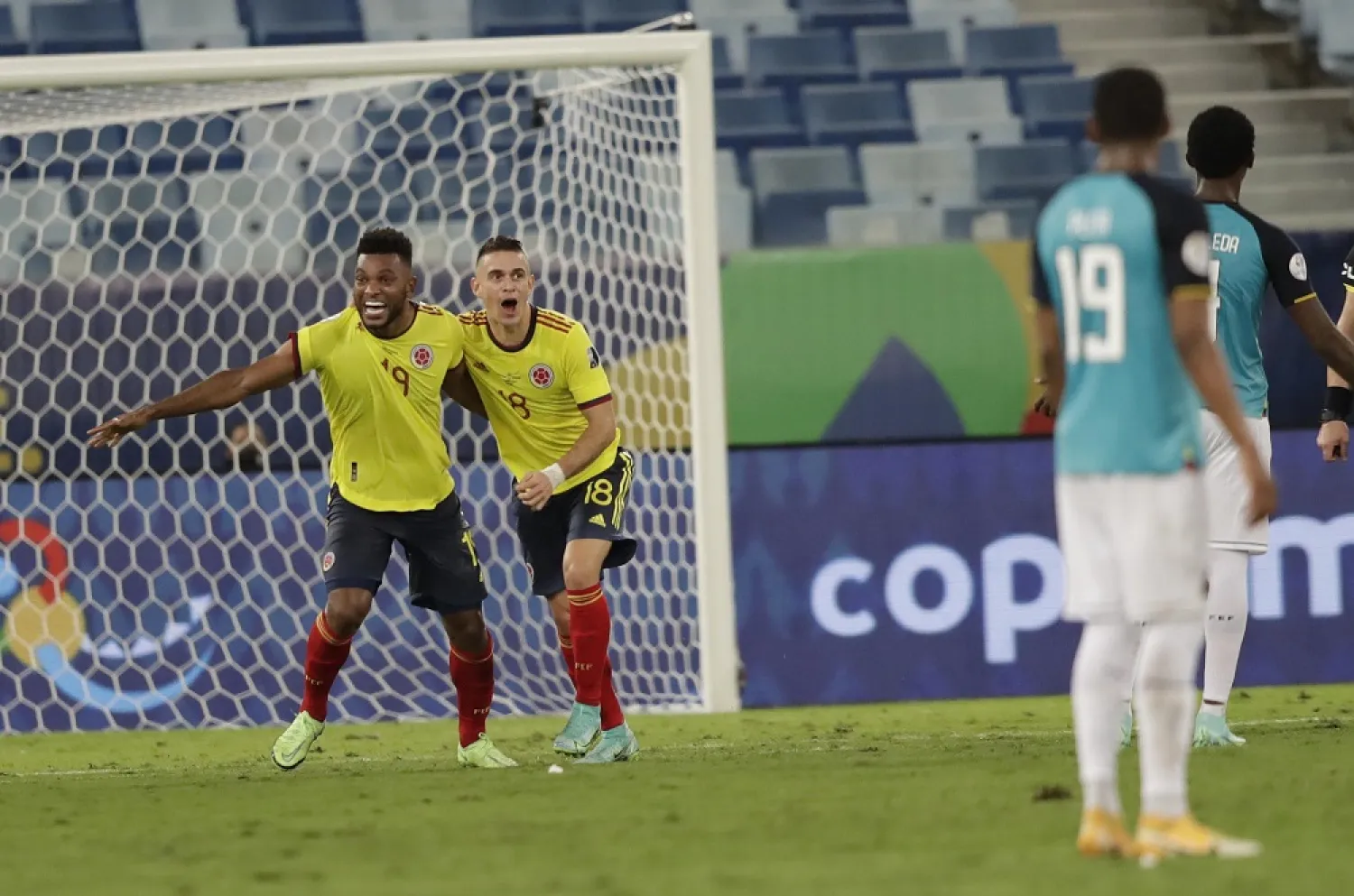 Colombia's Rafael Borre, left, and Miguel Borja celebrate the opening goal scored by Edwin Cardona during the match against Ecuador at Arena Pantanal stadium in Cuiaba, Brazil, June 13, 2021. (AP)