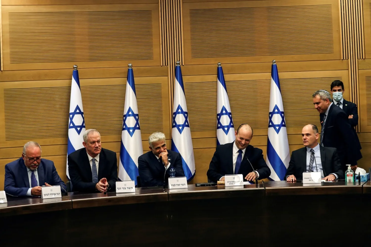 Israeli PM Naftali Bennett (second from right) and some members of his government attend its first Cabinet meeting, in Jerusalem, on June 13, 2021. (Reuters)