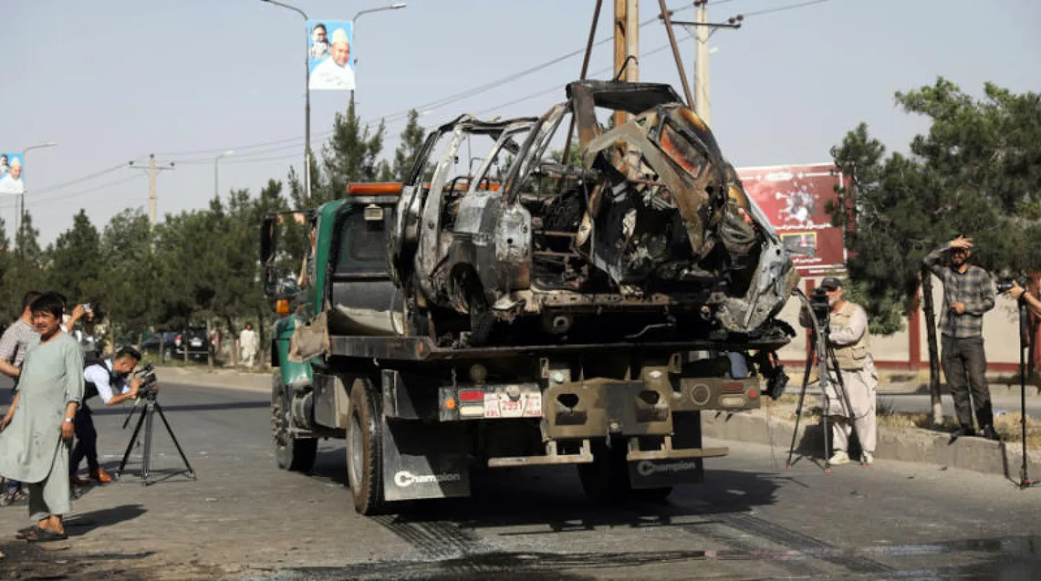 أفراد الأمن الأفغان يزيلون حافلة صغيرة متضررة بعد تفجيرها بقنبلة وسط العاصمة كابل أول من أمس (أ.ب)