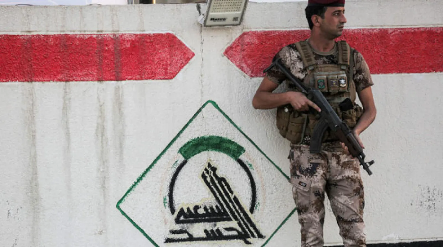 عنصر من «الحشد الشعبي» يحرس مقره الرئيسي ببغداد أول من أمس (أ.ف.ب)