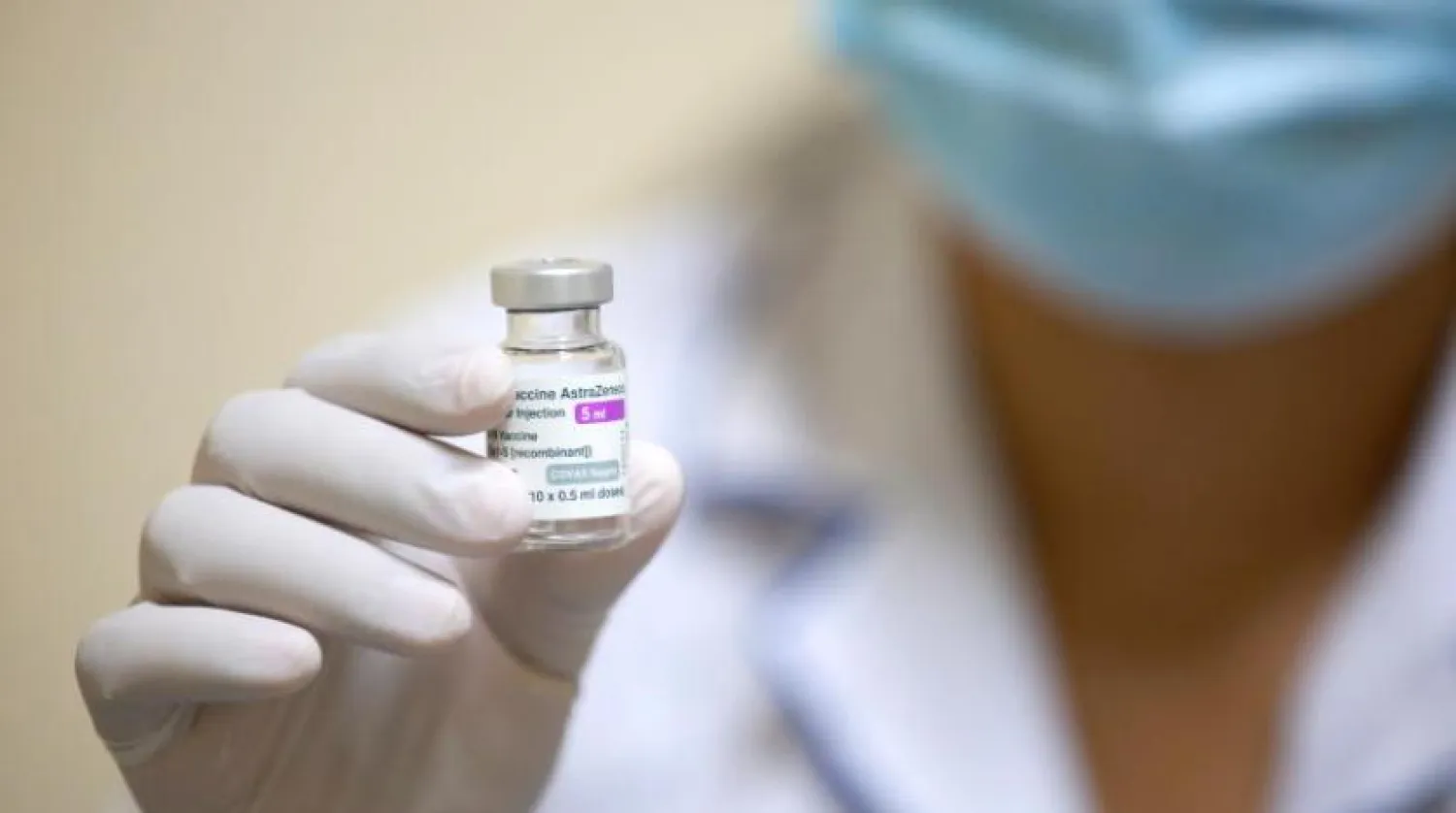 Bir hemşire AstraZeneca  aşısını içeren bir şişe tutuyor. (EPA)
