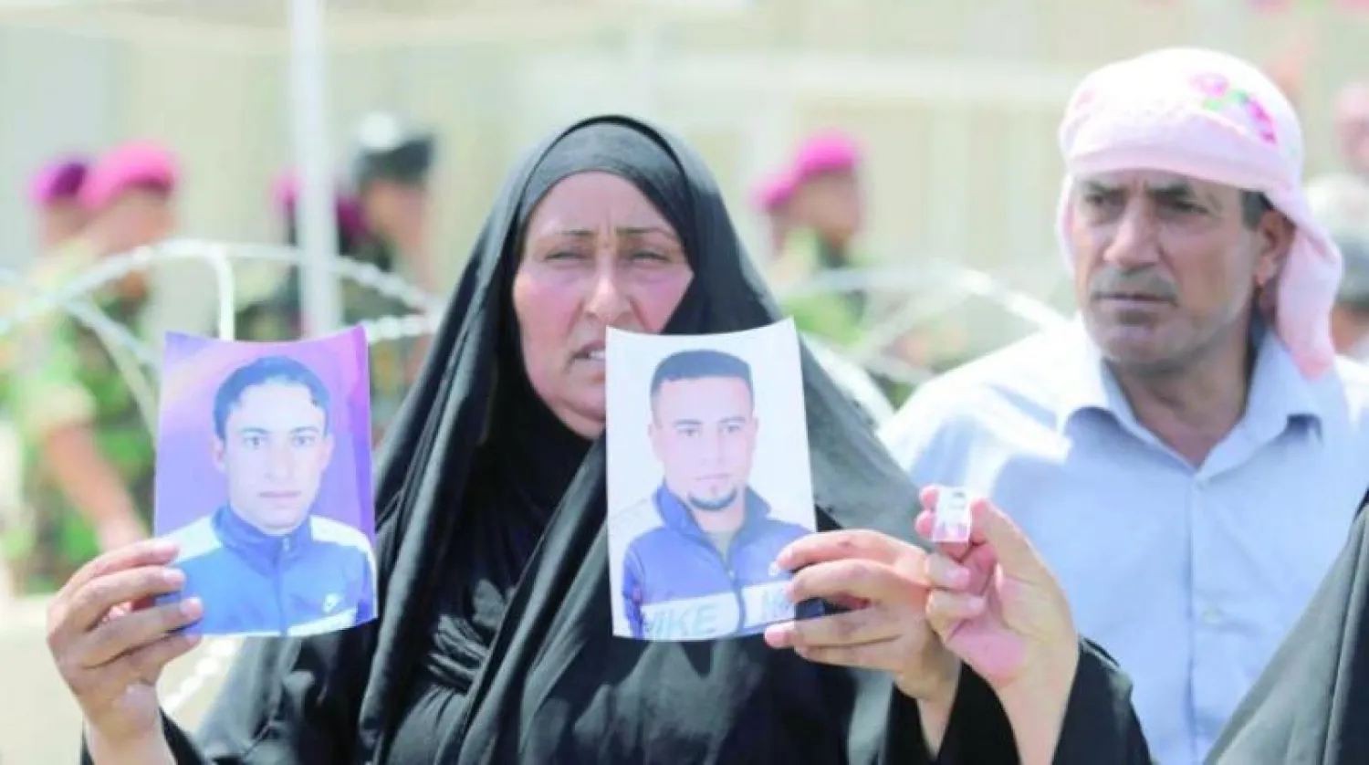 أهالي الضحايا يرفعون صور أولادهم الذين قضوا في مجزرة «سبايكر» عام 2014 (أرشيفية - الشرق الأوسط)