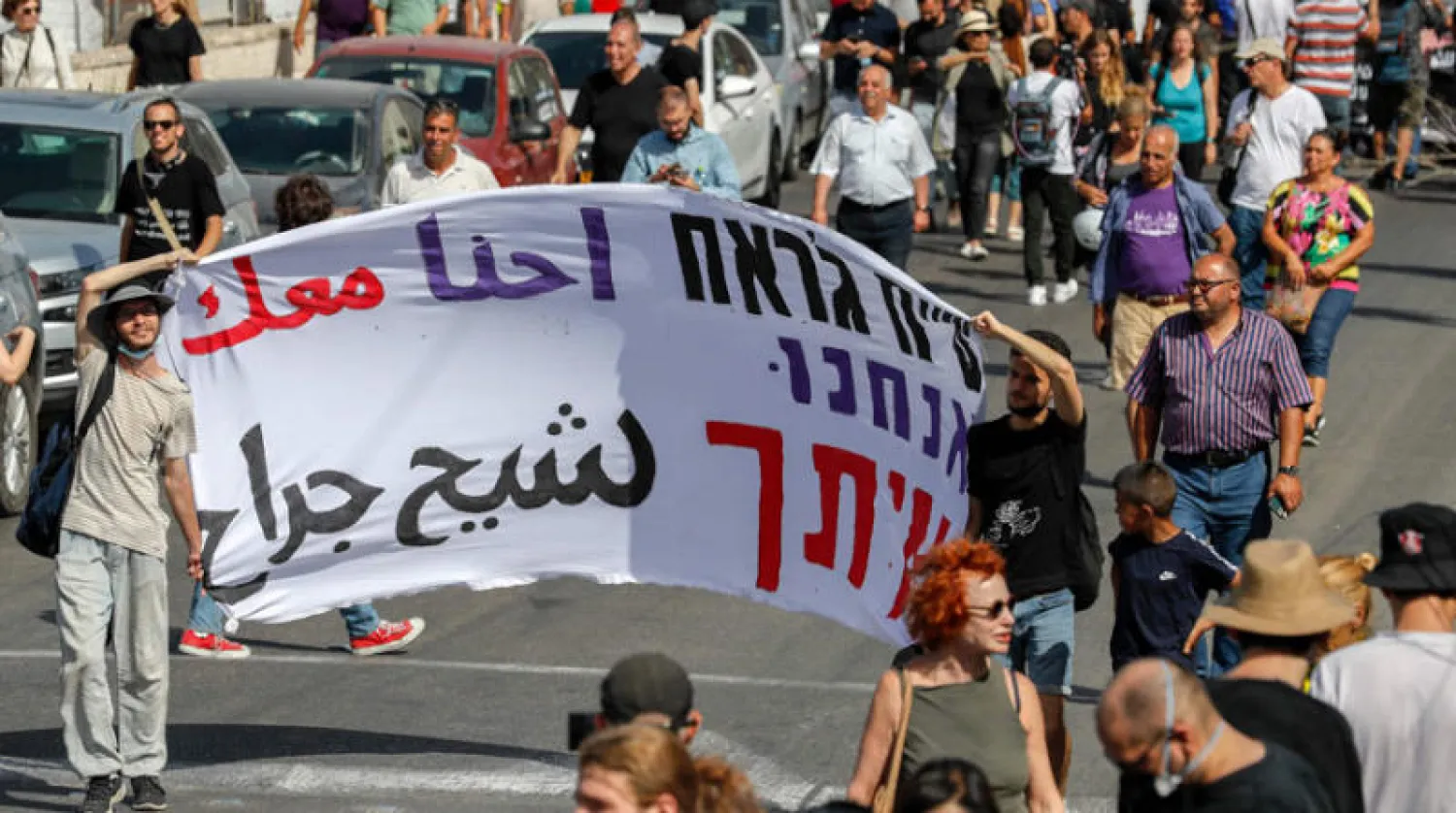 ناشطون فلسطينيون وإسرائيليون وأجانب يحتجون على إجلاء عائلات من حي الشيخ جراح بالقدس (أ.ف.ب)