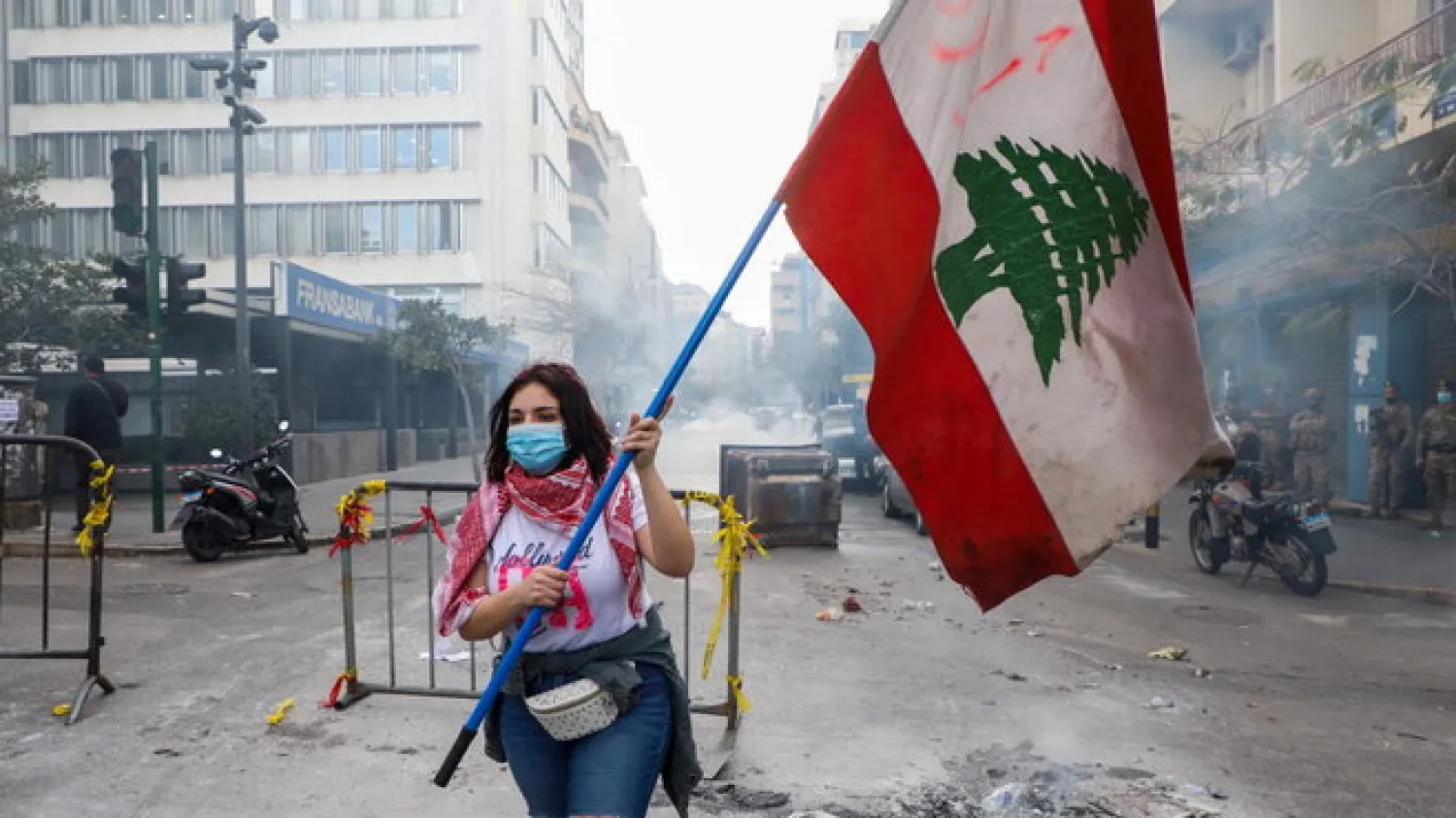 A demonstrator carries a national flag during a protest against mounting economic hardships, near the Central Bank building, in Beirut. (Reuters)
