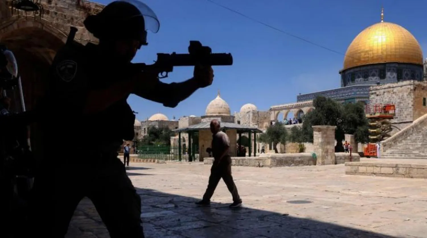 Mescid-i Aksa'daki Filistinlilere plastik mermi sıkan bir İsrail polisi. (AFP)