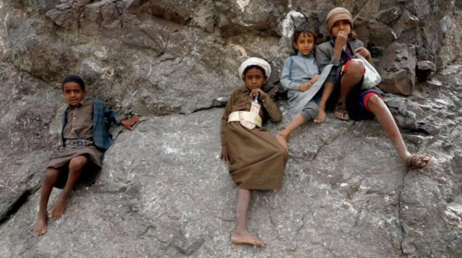 Yemeni children sit on the rocks of a mountain in the Bani Matar district in Sana’a (EPA)

