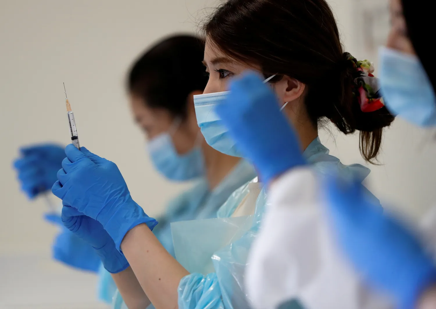 A health worker fills a syringe with a dose of the Pfizer-BioNTech coronavirus disease (COVID-19) vaccine at the Noevir Stadium Kobe, the home venue of Japanese professional soccer club Vissel Kobe and currently acting as a large-scale COVID-19 vaccination center, in Kobe, Japan June 12, 2021. REUTERS/Issei Kato