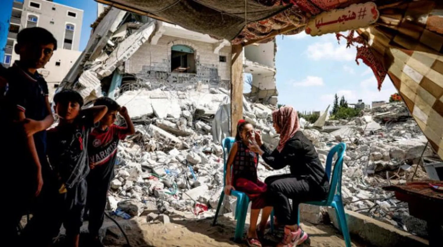 İsrail'in Gazze'nin kuzeyinde düzenlediği saldırılarda yıkılan bir bina içinde çocukların yüzlerine Filistin bayrağı çiziliyor (AFP)