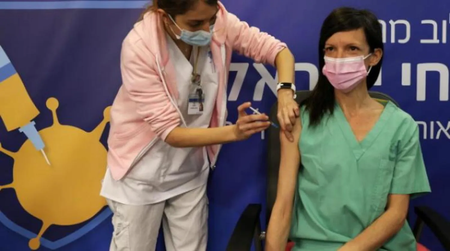 واحدة من أفراد الطاقم الطبي في إسرائيل تتلقى الجرعة الثانية من لقاح فايزر (رويترز)
