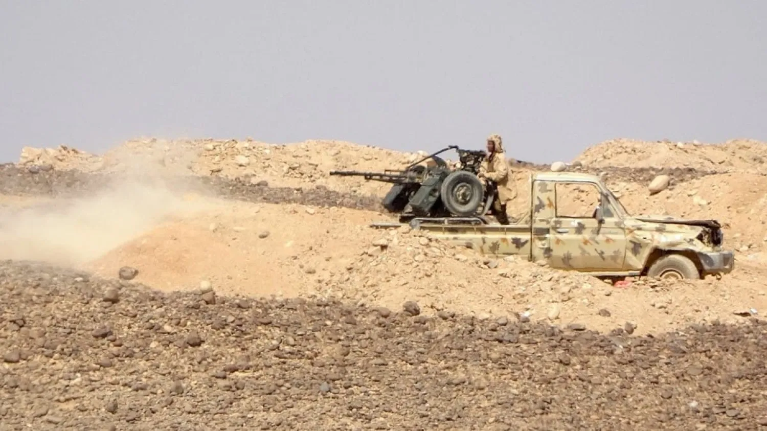 Government forces fire towards Houthi fighters during clashes northwest of Marib in central Yemen. (AFP)