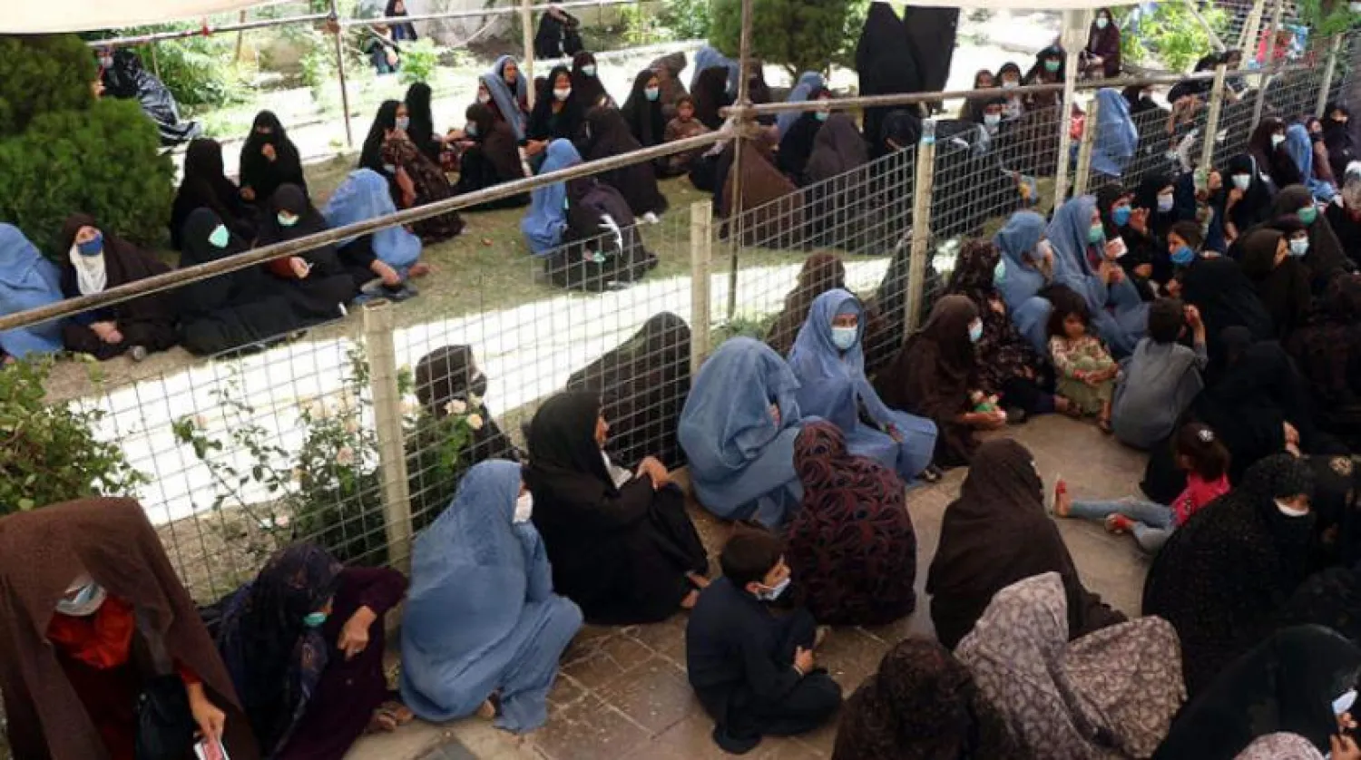 Afgan aileler Afganistan'ın batısındaki Herat'ta Dünya Gıda Programı'nın yardımını beklerken (AFP)